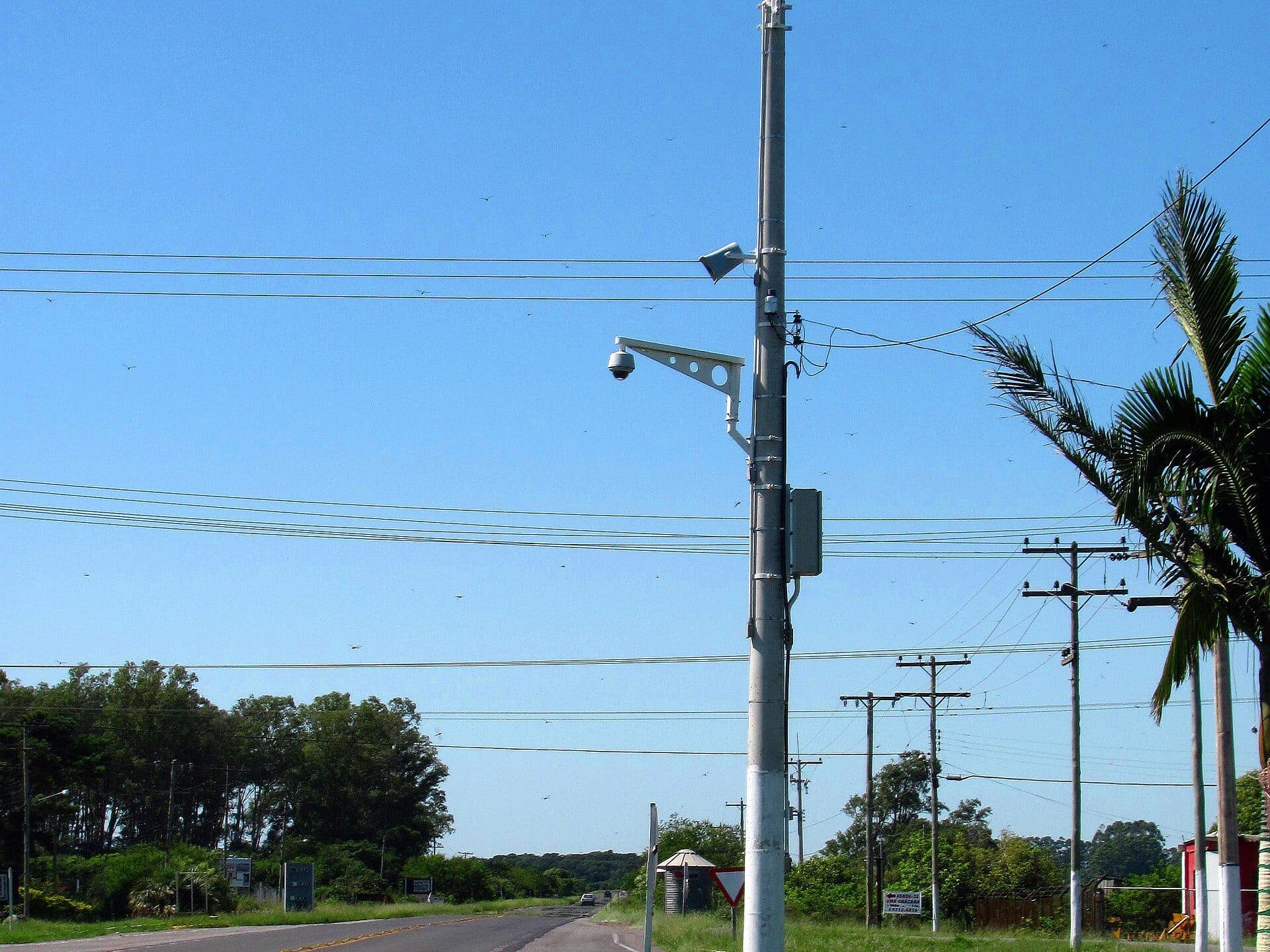 Câmera de segurança em formato de domo instalada num poste ao lado de uma estrada, em Palmares do Sul (RS).