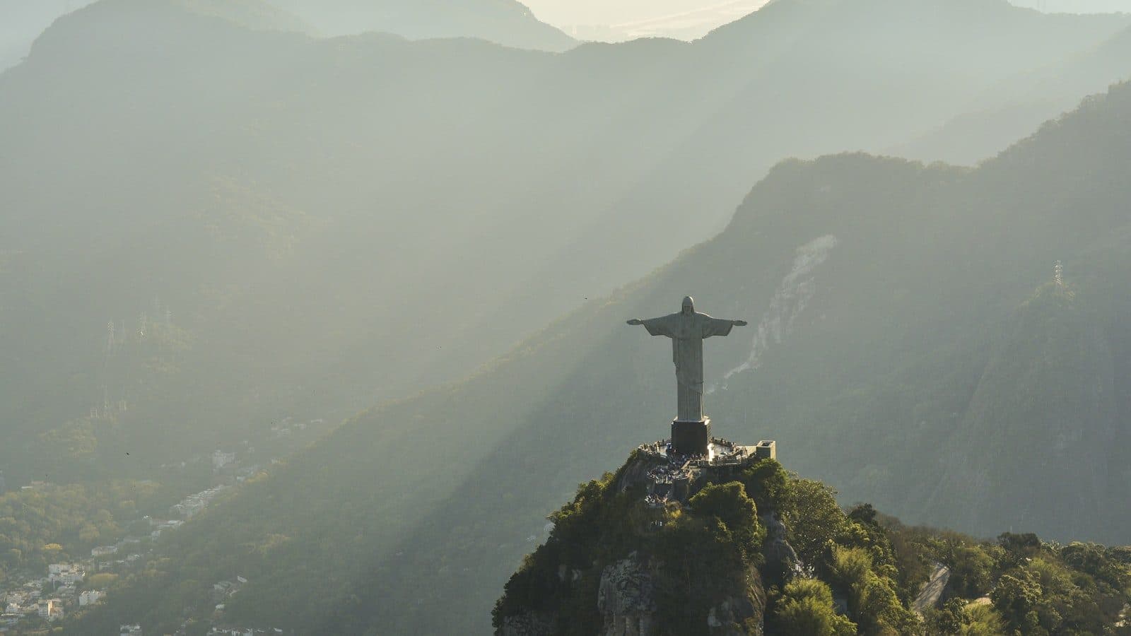 Cristo Redentor visto do alto, com a Floresta da Tijuca e os bairros do Rio ao fundo